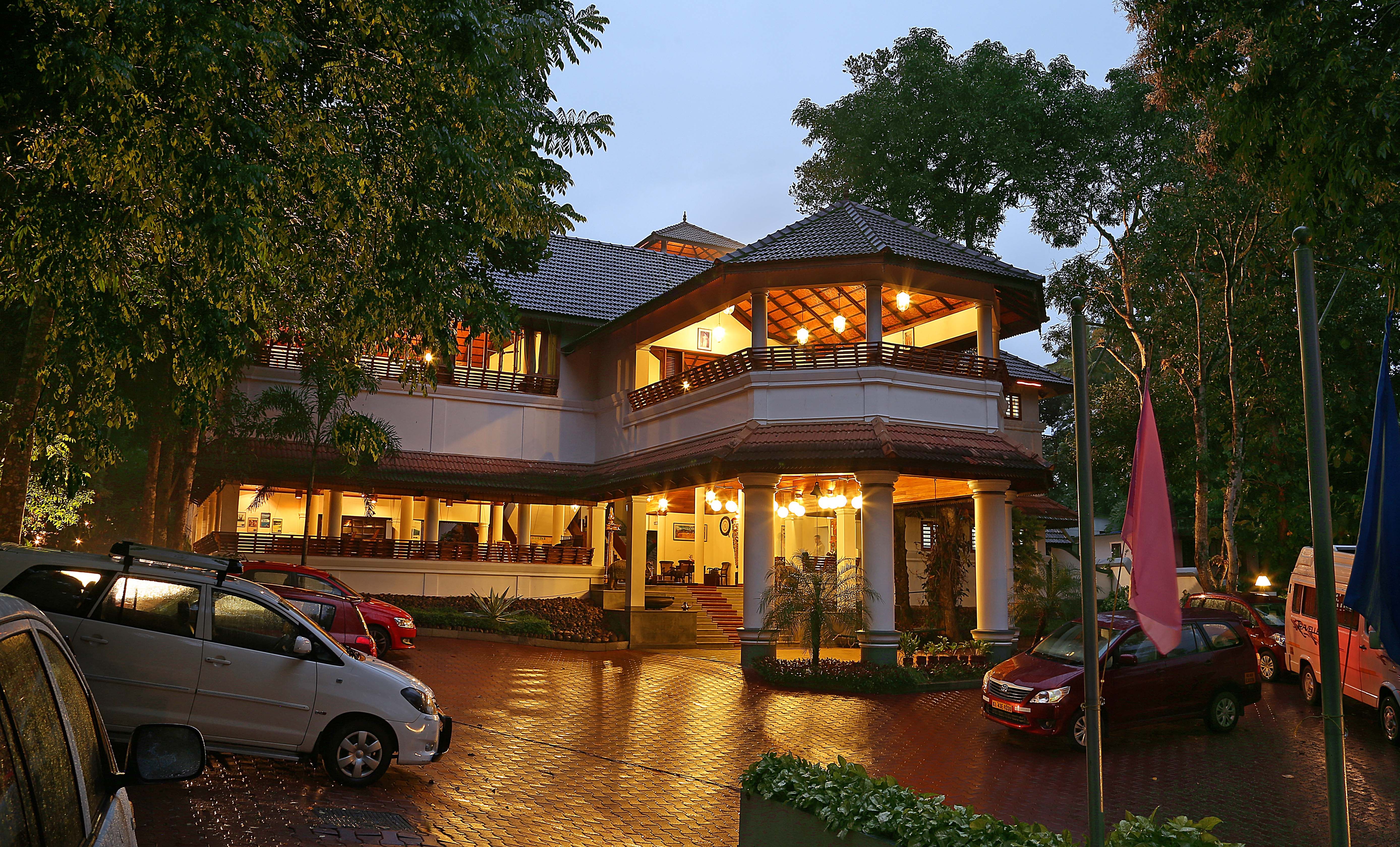 Illuminated traditional Kerala resort architecture at dusk