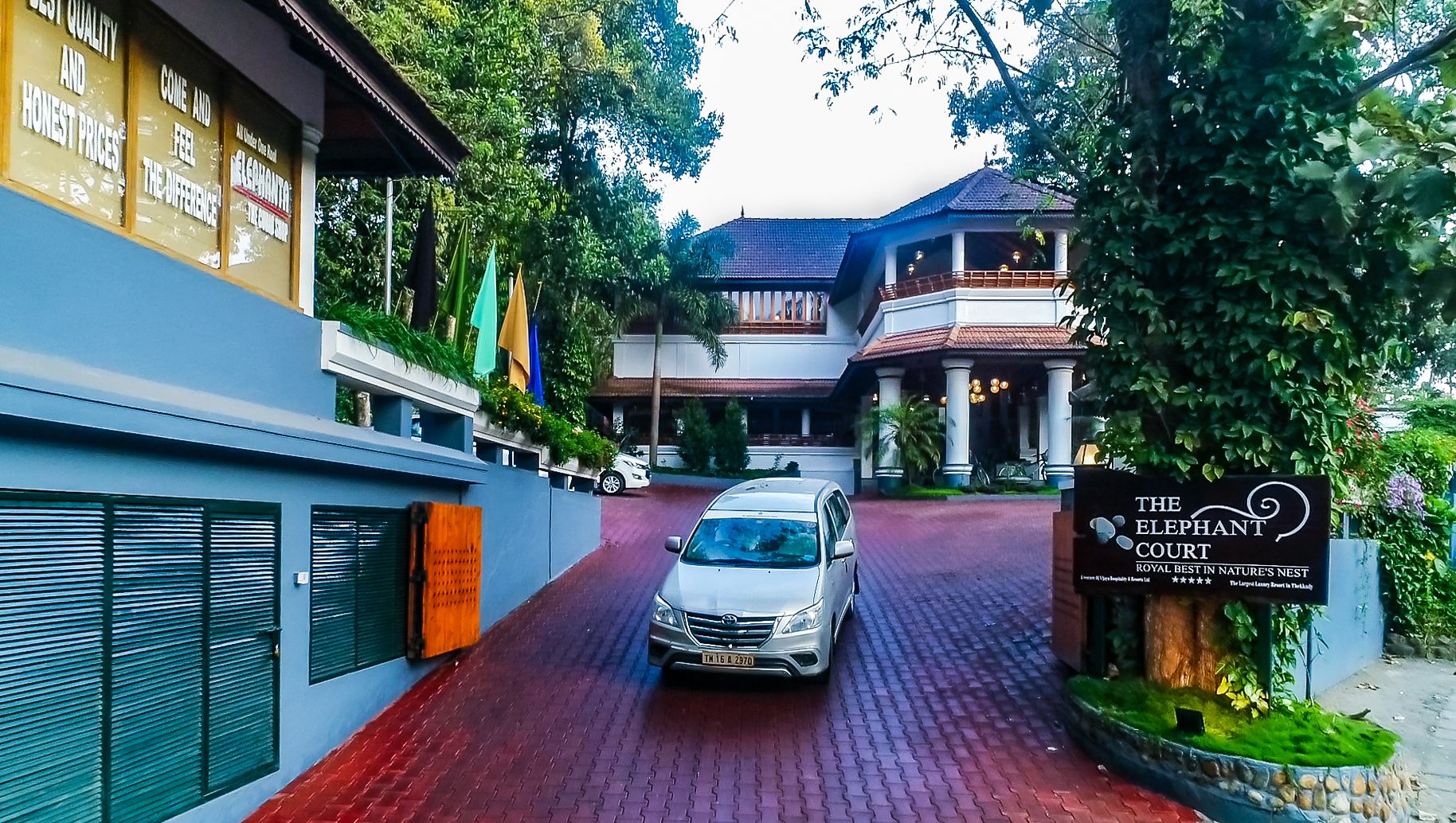 Paved entrance driveway and lush resort facade